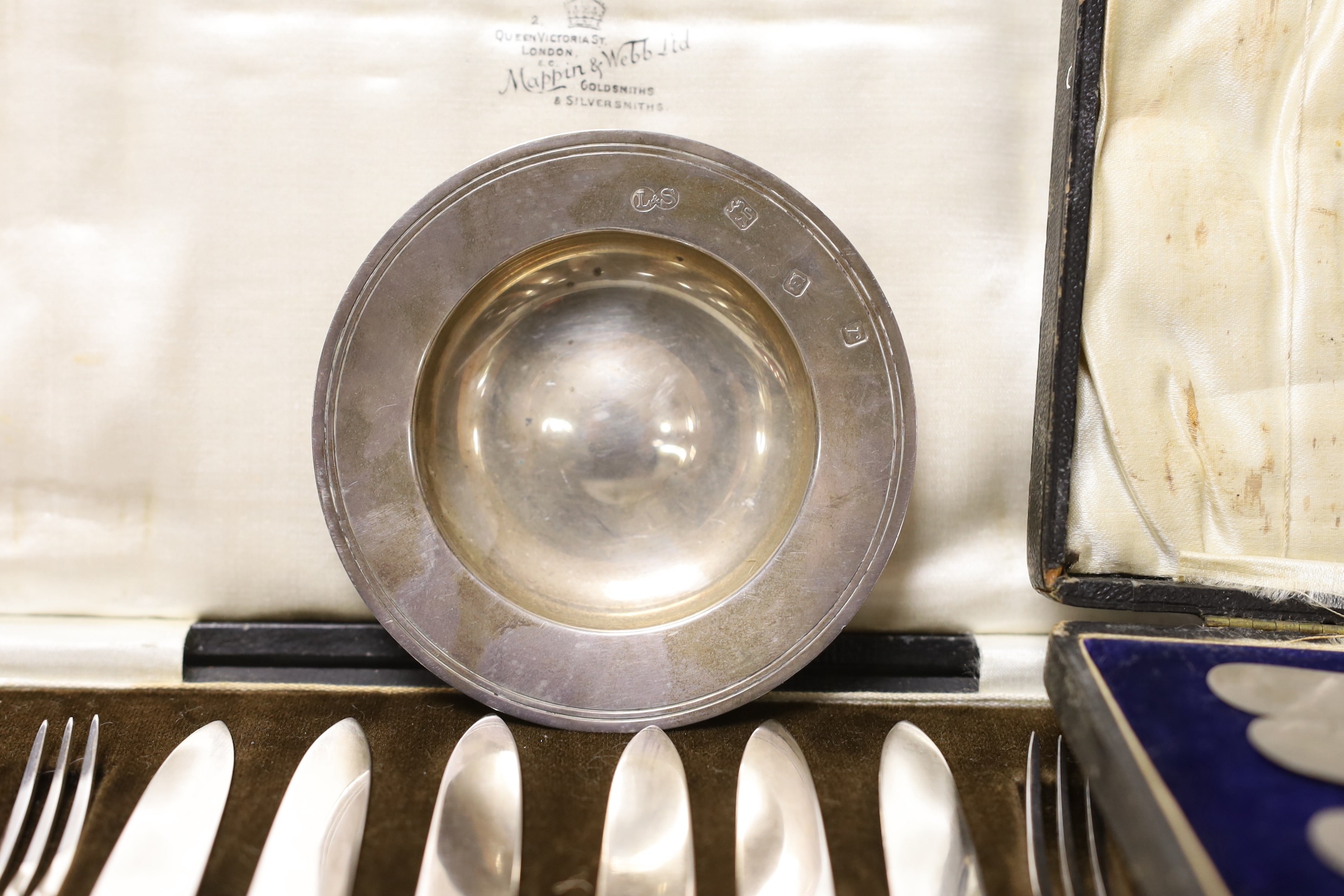 A cased set of six silver coffee spoons, a cased set of six silver-handled dessert knives, a small silver dish and a cased set of plated dessert knives and forks